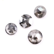 Round brilliant cut lab grown salt and pepper diamond featuring natural black and white galaxy-like inclusions with a faceted surface and translucent gray body tone.