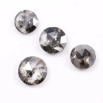 Round brilliant cut lab grown salt and pepper diamond featuring natural black and white galaxy-like inclusions with a faceted surface and translucent gray body tone.