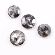 Round brilliant cut lab grown salt and pepper diamond featuring natural black and white galaxy-like inclusions with a faceted surface and translucent gray body tone.