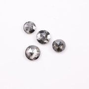 Round brilliant cut lab grown salt and pepper diamond featuring natural black and white galaxy-like inclusions with a faceted surface and translucent gray body tone.