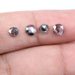 Round brilliant cut lab grown salt and pepper diamond featuring natural black and white galaxy-like inclusions with a faceted surface and translucent gray body tone.