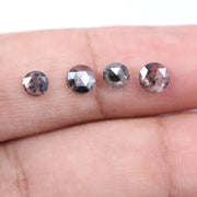 Round brilliant cut lab grown salt and pepper diamond featuring natural black and white galaxy-like inclusions with a faceted surface and translucent gray body tone.