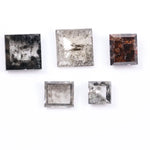 Five square step-cut lab grown diamonds with pyramid-style faceting and visible natural inclusions displayed on a white background, featuring clear, salt and pepper, and champagne tones.