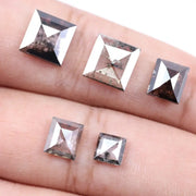 Five square step-cut lab grown diamonds with pyramid-style faceting and visible natural inclusions displayed on a white background, featuring clear, salt and pepper, and champagne tones.