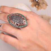 Victorian marquise black diamond ring with an emerald halo in a sterling silver cocktail setting.
