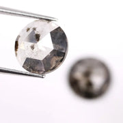 Pair of round rose cut lab grown salt and pepper diamonds with smoky gray tone and natural black inclusions, flat back faceting, matching loose stones for custom engagement rings or jewelry design.