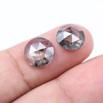 Pair of round rose cut lab grown salt and pepper diamonds with smoky gray tone and natural black inclusions, flat back faceting, matching loose stones for custom engagement rings or jewelry design.