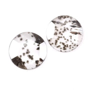Two round brilliant cut lab grown diamonds with black galaxy-style inclusions on white background, faceted loose stones for custom fine jewelry.
