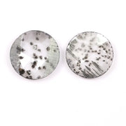 Two round brilliant cut lab grown diamonds with black galaxy-style inclusions on white background, faceted loose stones for custom fine jewelry.
