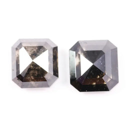 Emerald cut lab grown salt and pepper diamond with geometric step cut facets featuring bold black and smoky inclusions, octagonal shape, ethical sustainable gemstone.