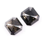 Emerald cut lab grown salt and pepper diamond with geometric step cut facets featuring bold black and smoky inclusions, octagonal shape, ethical sustainable gemstone.