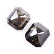 Emerald cut lab grown salt and pepper diamond with geometric step cut facets featuring bold black and smoky inclusions, octagonal shape, ethical sustainable gemstone.