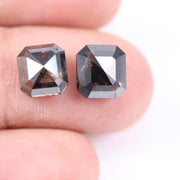 Emerald cut lab grown salt and pepper diamond with geometric step cut facets featuring bold black and smoky inclusions, octagonal shape, ethical sustainable gemstone.
