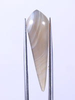 Teardrop-shaped object on a stand against a light purple background