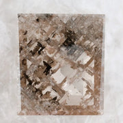 Emerald cut lab grown diamond featuring dramatic salt and pepper style inclusions with natural branching patterns, clear faceting and a unique galaxy-like internal structure.