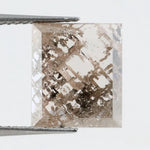 Emerald cut lab grown diamond featuring dramatic salt and pepper style inclusions with natural branching patterns, clear faceting and a unique galaxy-like internal structure.