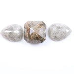 Three natural salt and pepper diamonds featuring two pear rose cut stones and one octagon step cut center diamond with visible inclusions and raw earthy tones, ideal for bespoke engagement ring or artisan jewelry design.