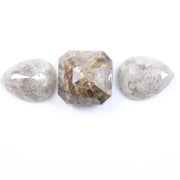 Three natural salt and pepper diamonds featuring two pear rose cut stones and one octagon step cut center diamond with visible inclusions and raw earthy tones, ideal for bespoke engagement ring or artisan jewelry design.