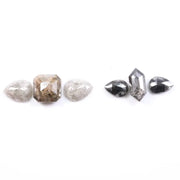 Assorted natural salt and pepper and white rustic diamonds in pear, hexagon, and elongated geometric cuts displayed on a white background, featuring visible inclusions and raw organic patterns.