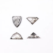 Four salt and pepper lab grown diamonds in shield, trillion, and geometric fancy cuts with natural grey inclusions, displayed on white background as loose ethical conflict-free stones for custom jewelry.