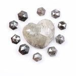 Large natural salt and pepper diamond heart surrounded by matching hexagon rose cut natural diamonds with visible galaxy-style inclusions on white background