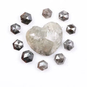 Large natural salt and pepper diamond heart surrounded by matching hexagon rose cut natural diamonds with visible galaxy-style inclusions on white background