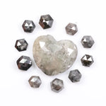 Large natural salt and pepper diamond heart surrounded by matching hexagon rose cut natural diamonds with visible galaxy-style inclusions on white background