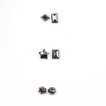Six natural black diamonds in geometric cuts including star, kite, emerald rectangle, pentagon, and round brilliant shapes displayed on white background.