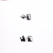 Six natural black diamonds in geometric cuts including star, kite, emerald rectangle, pentagon, and round brilliant shapes displayed on white background.