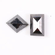Pair of natural black diamonds featuring a shield-shaped cut and an elongated baguette-style cut, loose matching set with faceted surfaces for custom fine jewelry design.