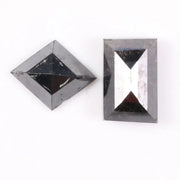 Pair of natural black diamonds featuring a shield-shaped cut and an elongated baguette-style cut, loose matching set with faceted surfaces for custom fine jewelry design.