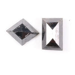 Pair of natural black diamonds featuring a shield-shaped cut and an elongated baguette-style cut, loose matching set with faceted surfaces for custom fine jewelry design.