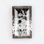 Rectangular step cut lab grown diamond featuring dramatic black dendritic inclusions in a salt and pepper pattern, creating a unique one of a kind modern alternative diamond with striking natural looking carbon formations inside a clear faceted stone.