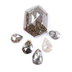 Set of natural salt and pepper diamonds including one hexagon cut center stone and five pear-shaped diamonds with visible inclusions and earthy brown, gray, and translucent tones on white background.