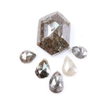 Set of natural salt and pepper diamonds including one hexagon cut center stone and five pear-shaped diamonds with visible inclusions and earthy brown, gray, and translucent tones on white background.