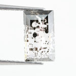 Rectangular step cut lab grown diamond featuring dramatic black dendritic inclusions in a salt and pepper pattern, creating a unique one of a kind modern alternative diamond with striking natural looking carbon formations inside a clear faceted stone.