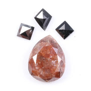 Large natural pear-shaped orange diamond with visible inclusions, surrounded by three black geometric-cut natural diamonds on a white background.