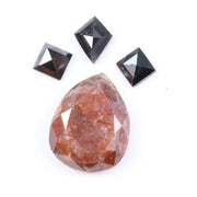 Large natural pear-shaped orange diamond with visible inclusions, surrounded by three black geometric-cut natural diamonds on a white background.