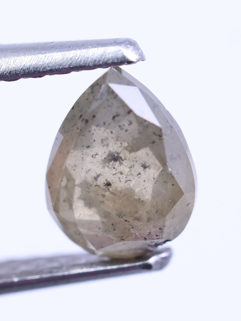 Faceted diamond held between tweezers on a white background