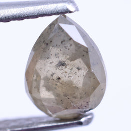 Faceted diamond held between tweezers on a white background