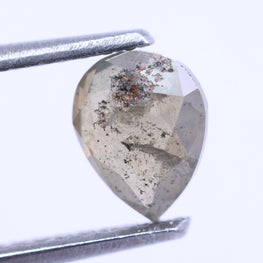 pear-shaped diamond held by tweezers on a white background