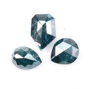 Three natural teal blue diamonds featuring pear, oval, and shield cuts with visible galaxy-like inclusions, rare salt and pepper natural diamonds ideal for custom jewelry design