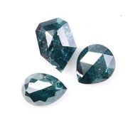 Three natural teal blue diamonds featuring pear, oval, and shield cuts with visible galaxy-like inclusions, rare salt and pepper natural diamonds ideal for custom jewelry design