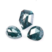 Three natural teal blue diamonds featuring pear, oval, and shield cuts with visible galaxy-like inclusions, rare salt and pepper natural diamonds ideal for custom jewelry design