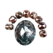Large natural green diamond surrounded by fancy cognac brown natural diamonds arranged in a semicircle, showcasing rare earth-mined colored diamonds with visible natural inclusions and unique faceting.