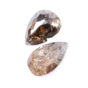 Pair of natural brown diamonds showing raw crystal inclusions and faceted pear shapes with cognac tones, genuine earth mined gemstones with natural internal patterns and rough texture ideal for collectors, jewelers, and natural diamond enthusiasts.