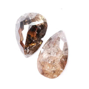 Pair of natural brown diamonds showing raw crystal inclusions and faceted pear shapes with cognac tones, genuine earth mined gemstones with natural internal patterns and rough texture ideal for collectors, jewelers, and natural diamond enthusiasts.