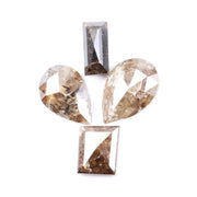 Natural brown salt and pepper diamond set featuring two pear shaped diamonds and two baguette step cut diamonds with visible natural inclusions and rustic champagne tones for custom jewelry design.
