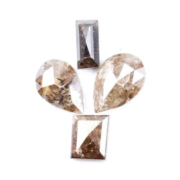 Natural brown salt and pepper diamond set featuring two pear shaped diamonds and two baguette step cut diamonds with visible natural inclusions and rustic champagne tones for custom jewelry design.