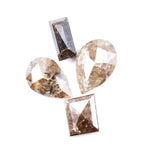Natural brown salt and pepper diamond set featuring two pear shaped diamonds and two baguette step cut diamonds with visible natural inclusions and rustic champagne tones for custom jewelry design.
